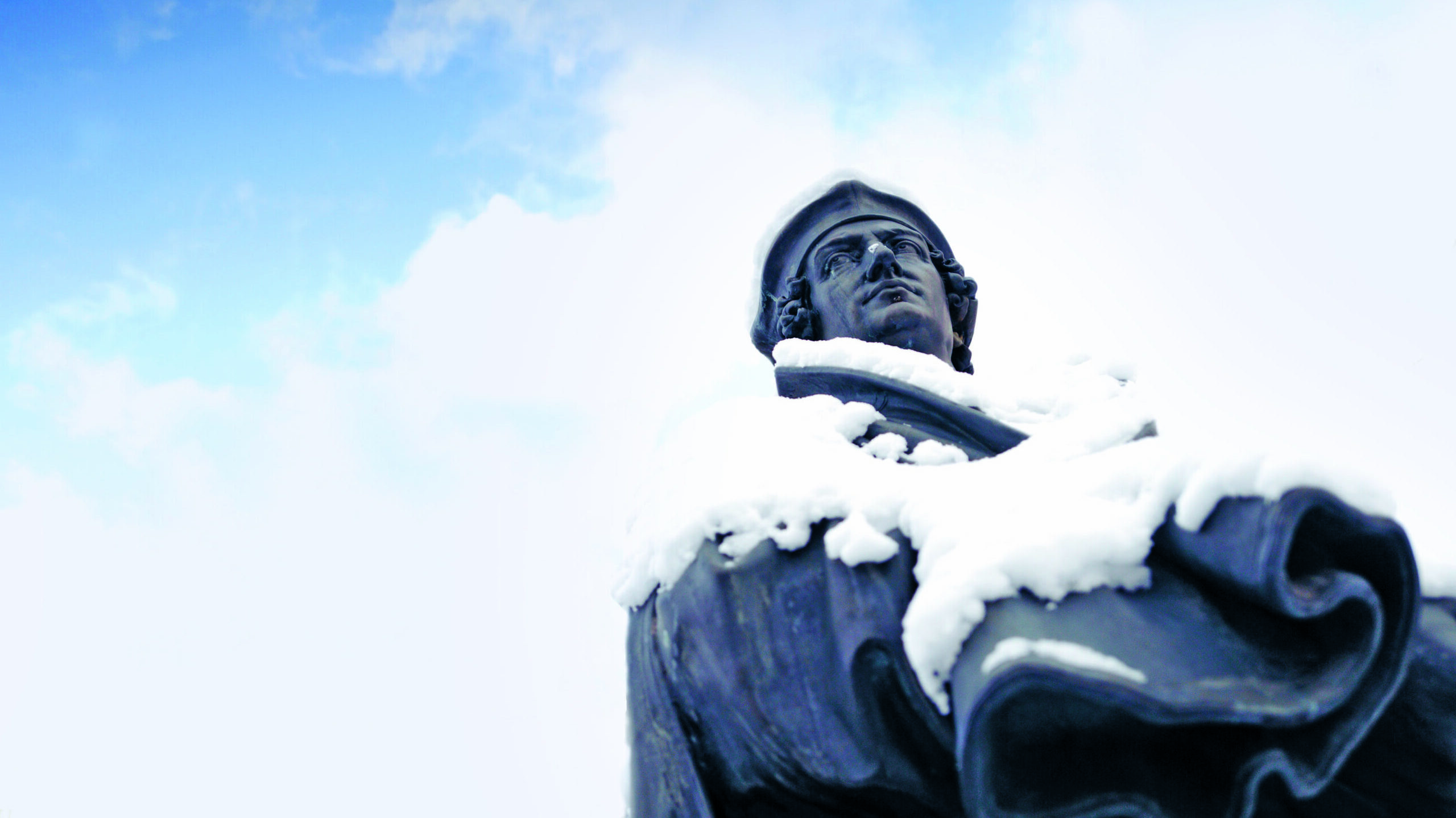 Johannes Reuchlin Statue im Schnee vor blauem Himmel